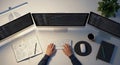 Top-down view of a programmer working late at a clean desk with three screens showing code Royalty Free Stock Photo
