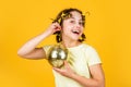 disco ball decoration. lovely girl with disco ball. Fashion girl posing in curlers on yellow wall. saturday night and Royalty Free Stock Photo