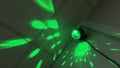Disco ball lights on ceiling in dark room. Red green blue flashes of stroboscope producing pattern on walls. film grain