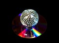 Disco ball over music CD on black