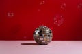 Disco ball on pink background with soap buble around