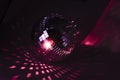 Disco ball shining in red light. party ball Laying in the dark Royalty Free Stock Photo