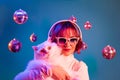 Disco woman with cat listening music with headphones, on studio background