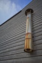 Discoloured stainless steel exhaust chimney, on wooden panelled building. Charmouth, Dorset.