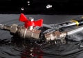 Disconnected flexible fittings, ball valve, union and adjustable wrench in water with falling drops Royalty Free Stock Photo