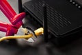 Disconnecting the Internet connection, cutting off the yellow Ethernet cable with wire cutters with a red handle on the Wi-Fi Royalty Free Stock Photo