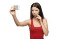 Discontent woman taking pictures of herself through cellphone