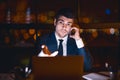 Discontented Businessman Talking On Mobile Phone Sitting In Modern Office