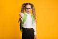 Discontented Schoolgirl Gesturing Thumbs Down Over Yellow Background Royalty Free Stock Photo