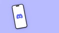 Discord Logo on Mobile Phone Screen on Blue Background with Copy Space
