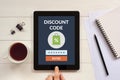 Discount code concept on tablet screen with office objects Royalty Free Stock Photo