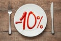 10 discount on food. Food sale. Plate with the inscription ketchup and fork with knife on wooden table