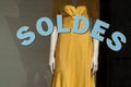 Discount sign  on window in french fashion store showroom on yellow summer dress background Royalty Free Stock Photo