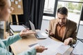 discouraged businessman pointing at graphs near