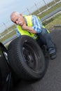 Discouraged retired man unable to change car tyre