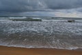 white reef kissing the beach, sun covered by dark cloud at the horizon, Sri Lanka Royalty Free Stock Photo