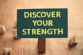 Discover your strength, text words typography written on paper against wooden background, life and business motivational