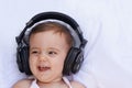 Discovering the joys of music. A cute baby girl laughing as she listens to music over headphones. Royalty Free Stock Photo