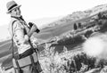 Smiling adventure woman hiker hiking in Tuscany with binoculars