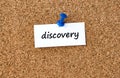 Discovery. Word written on a piece of paper, cork board background