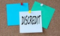 DISCREDIT - word on colorful pieces of paper attached to the note board Royalty Free Stock Photo