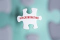 Discrimination word on puzzle pieces isolated on blurred background.