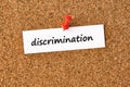 Discrimination. Word written on a piece of paper, cork board background