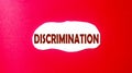 Discrimination written on a scrap of paper and a red background.