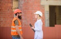 Discuss progress plan. Construction industry concept. Woman engineer and bearded brutal builder discuss construction Royalty Free Stock Photo