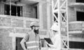 Discuss progress project. Safety inspector concept. Woman inspector and bearded brutal builder discuss construction Royalty Free Stock Photo