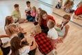 Discussing new dance perfomance. Full length portrait of young dance teacher talking to group of little girls and boys Royalty Free Stock Photo