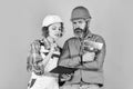 Discussing renovation with contractor. Plastering works. Couple look documents. Woman and man safety hard hat. Couple Royalty Free Stock Photo