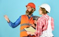 Discussing renovation with contractor. Price list. Couple look documents. Woman and man safety hard hat. Couple planning