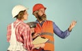 Discussing renovation with contractor. Price list. Couple look documents. Woman and man safety hard hat. Couple planning