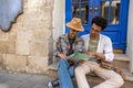 Young couple sitting on the door step and discussing the route Royalty Free Stock Photo