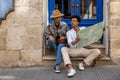 Young couple sitting on the door step and discussing the route Royalty Free Stock Photo