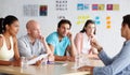 Discussing salary increases. A group of colleagues in a meeting in their office.