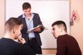 Discussion in the lesson. Youn teacher with book in background. Royalty Free Stock Photo