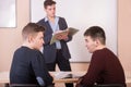 Discussion in the lesson. Young students and the teacher. Royalty Free Stock Photo