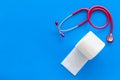 Toilet paper roll and stethoscope for proctology diseases concept on blue background top view mock up Royalty Free Stock Photo