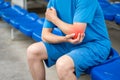 Diseases of the elbow joint, bone fracture and inflammation, athletic man on a sports ground after workout suffering from pain in
