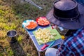 Camp cooking process. A man preparing vegetables to make a stew on a campfire. Camping life