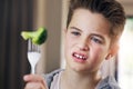 Disgust, food and fear with child and broccoli for nutrition, health and cooking. Sad, angry and dinner with boy and Royalty Free Stock Photo