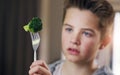 Disgust, food and refuse with child and broccoli for nutrition, health and cooking. Sad, angry and dinner with boy and Royalty Free Stock Photo