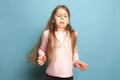 The disgust. Teen girl on a blue background. Facial expressions and people emotions concept