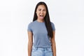 Disgusted asian young girl cringe from awful smell, sticking out tongue, squinting and wrinkle nose from aversion, toop Royalty Free Stock Photo