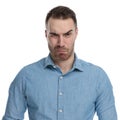 Disgusted casual man frowning while wearing blue shirt