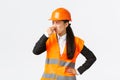 Disgusted and displeased asian female architect enter construction area and shut ears as smell disgusting reek, awful
