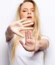 Disgusted stressed out angry young blond woman posing at studio wall, keeping hands in stop gesture Royalty Free Stock Photo