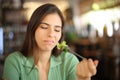 Disgusted woman eating lettuce in a restaurant
